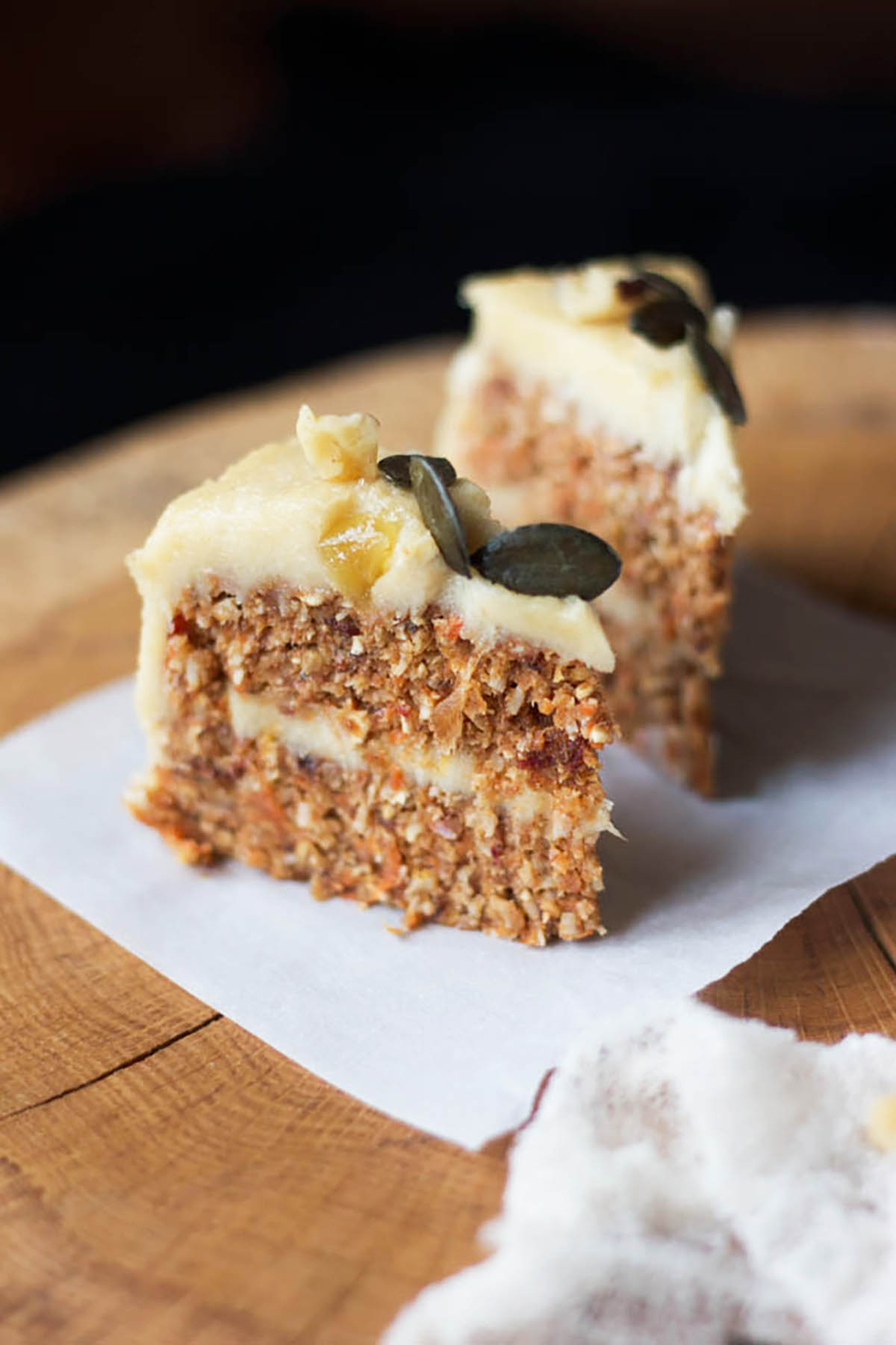 Two small slices of raw carrot cake with white frosting.