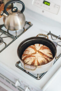 A loaf of sourdough bread in a pot on the stovetop