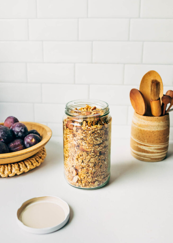 Basic Granola Ratio in a glass jar against a tile wall