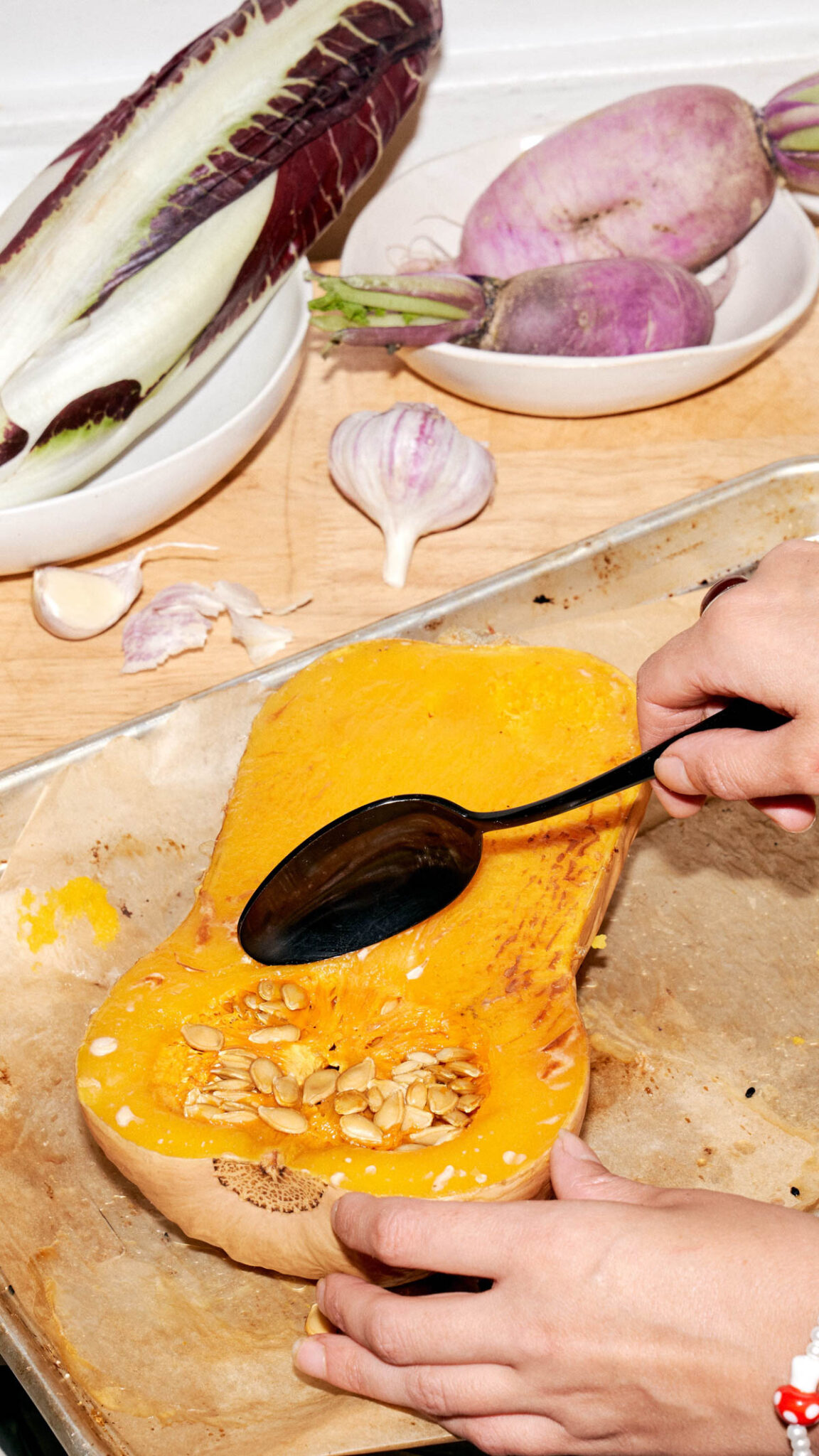 A spoon scooping out the flesh of a cooked butternut squash