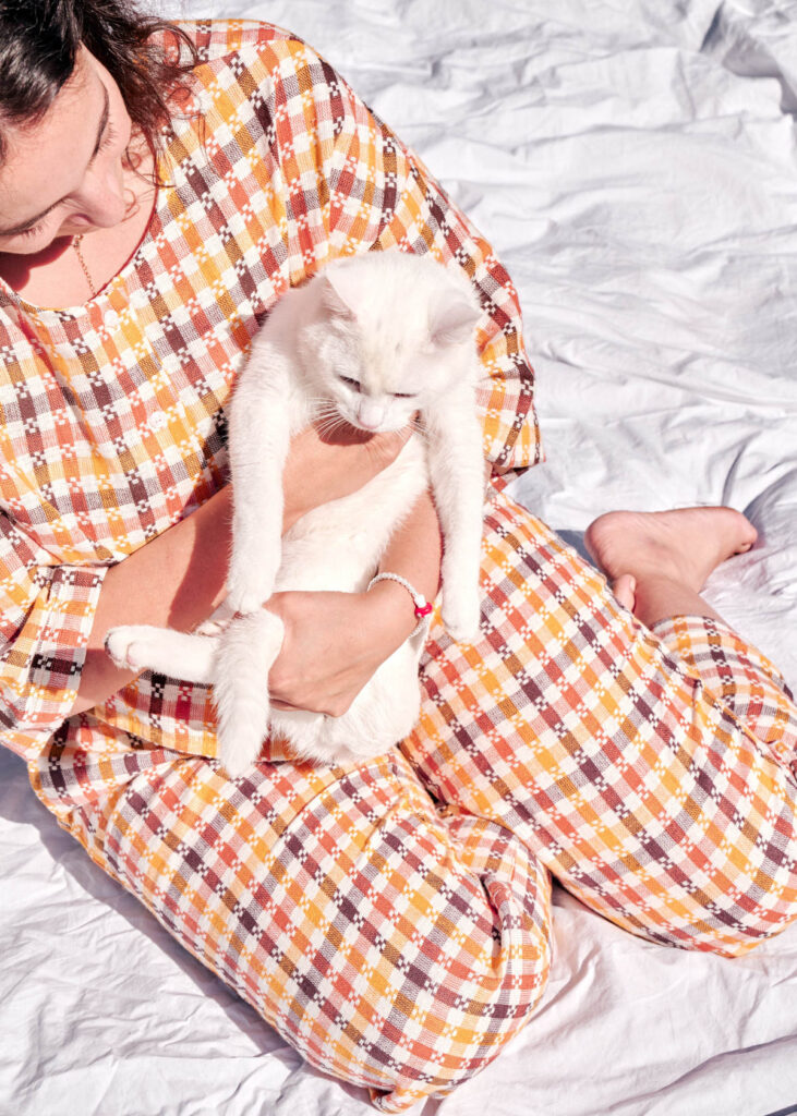 A woman in a plaid suit holding a white kitten
