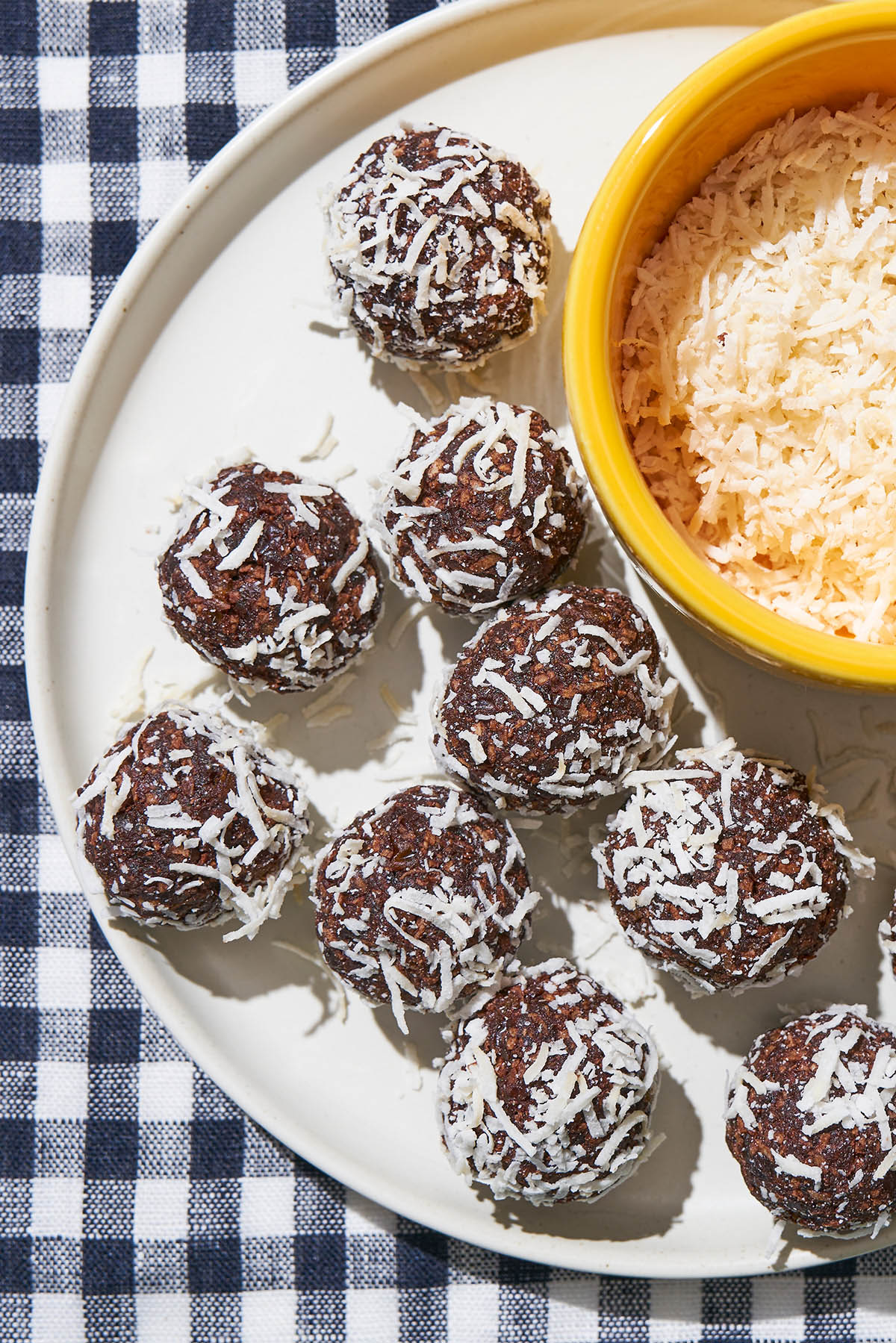 Close up of coconut-coated chocolate balls on a plate.