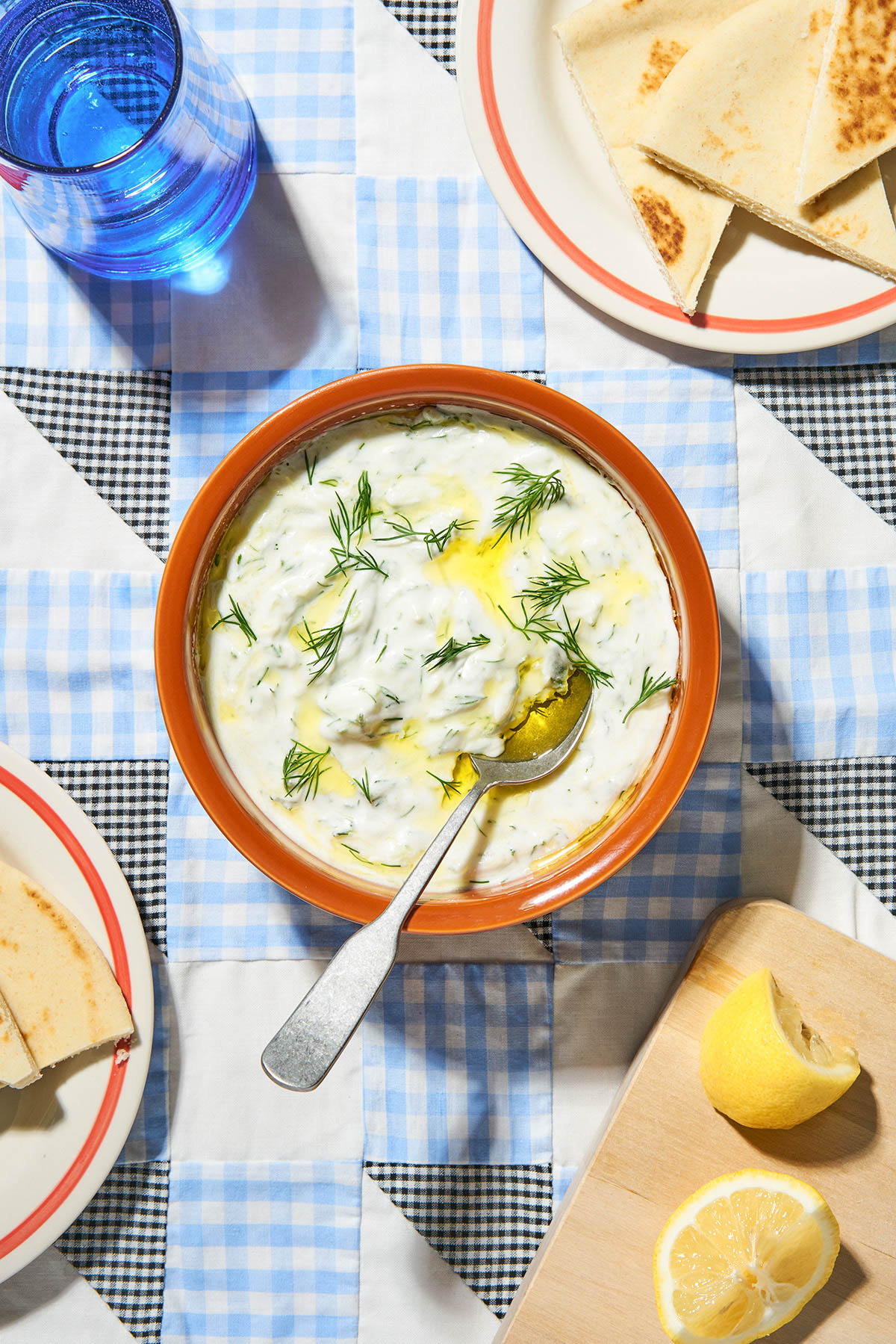 A bowl of yogurt dip topped with dill.