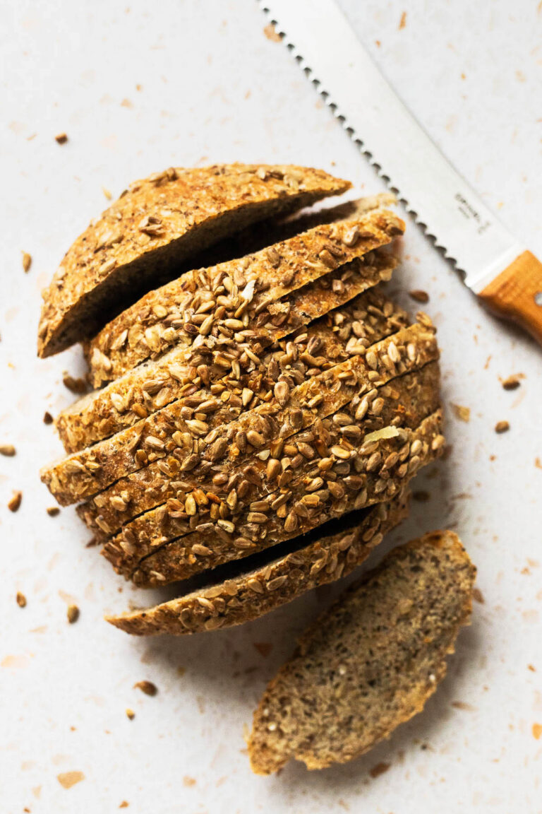 Sliced loaf of round bread topped with seeds, top-down view.
