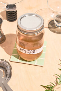 A jar labeled rosemary simple on a kitchen counter.