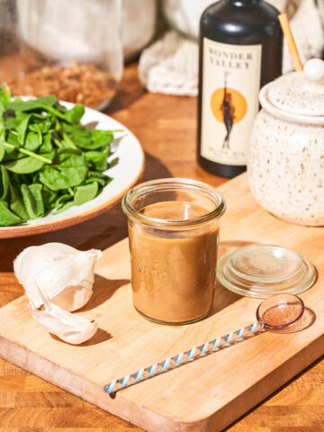 A vinaigrette in a glass jar on a kitchen counter.