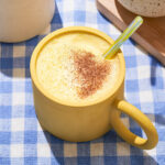 A foamy yellow drink in a yellow mug.