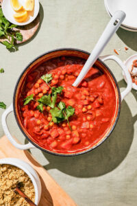 Top down view of a tomato stew in a large cooking pot.